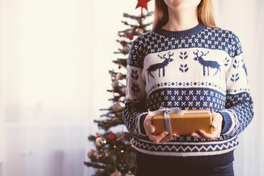 a woman wearing blue and white knitted sweaters with reindeer design