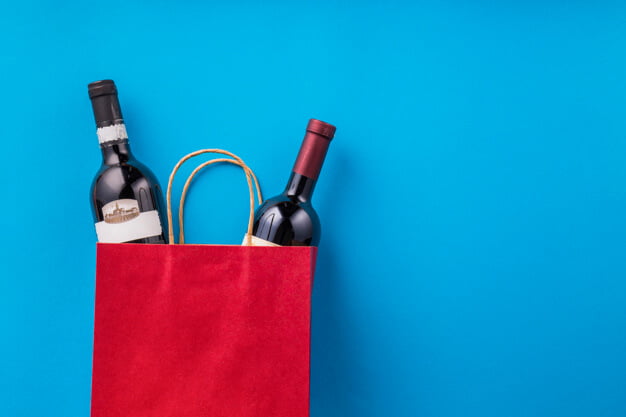 a red paper bag with two bottles of wine