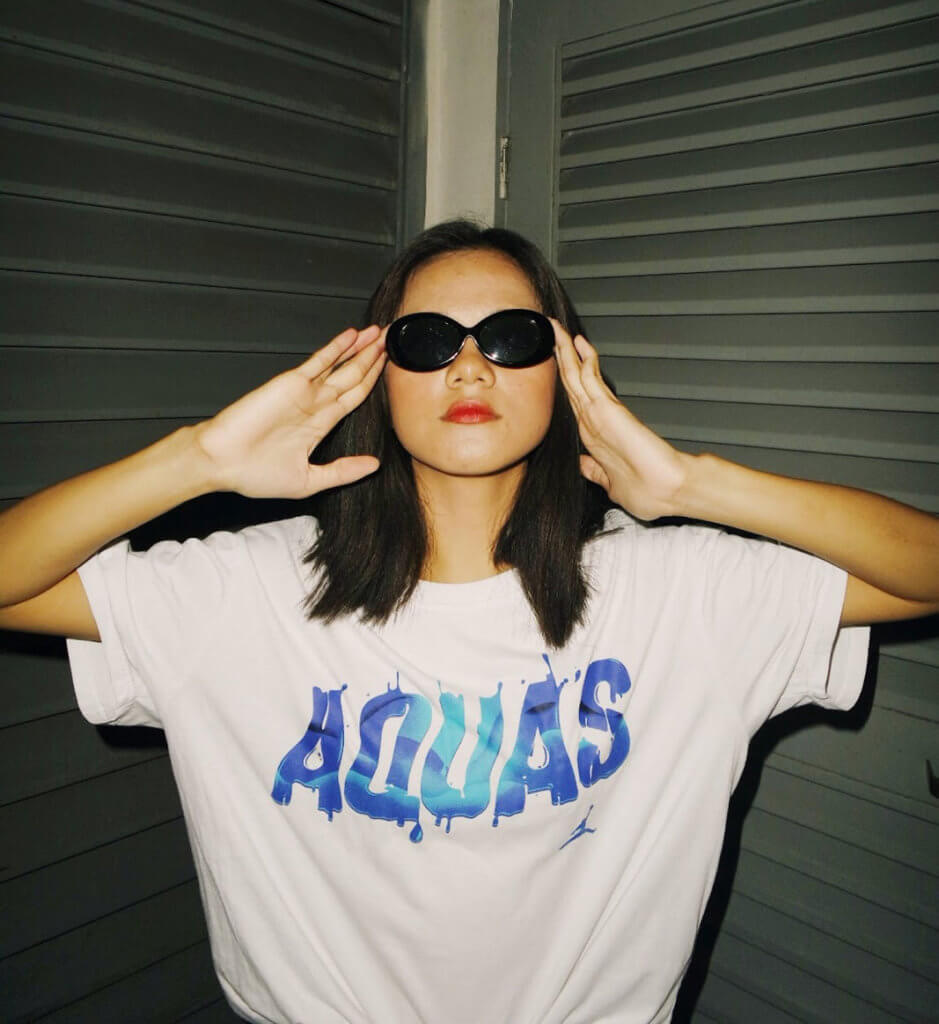 a woman wearing black sunglasses and a white shirt