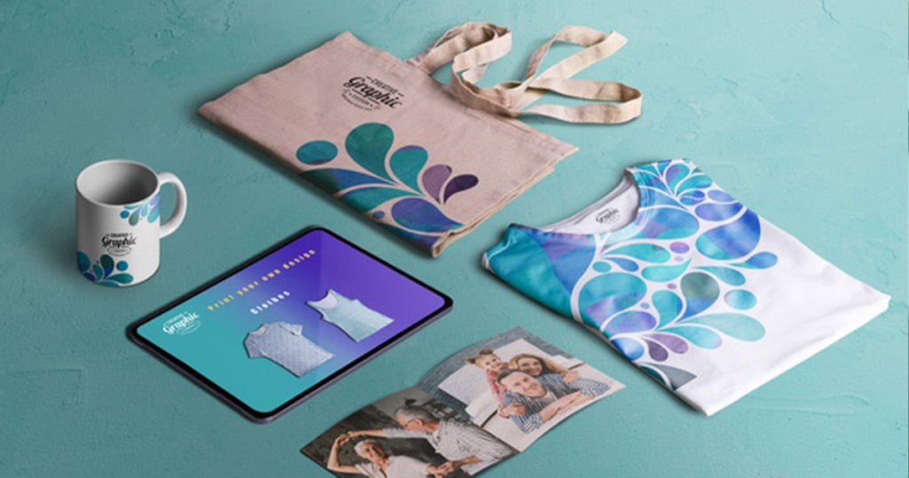 Mug, tablet, canvas bag, shirt, an open photo flat-laid side by side.